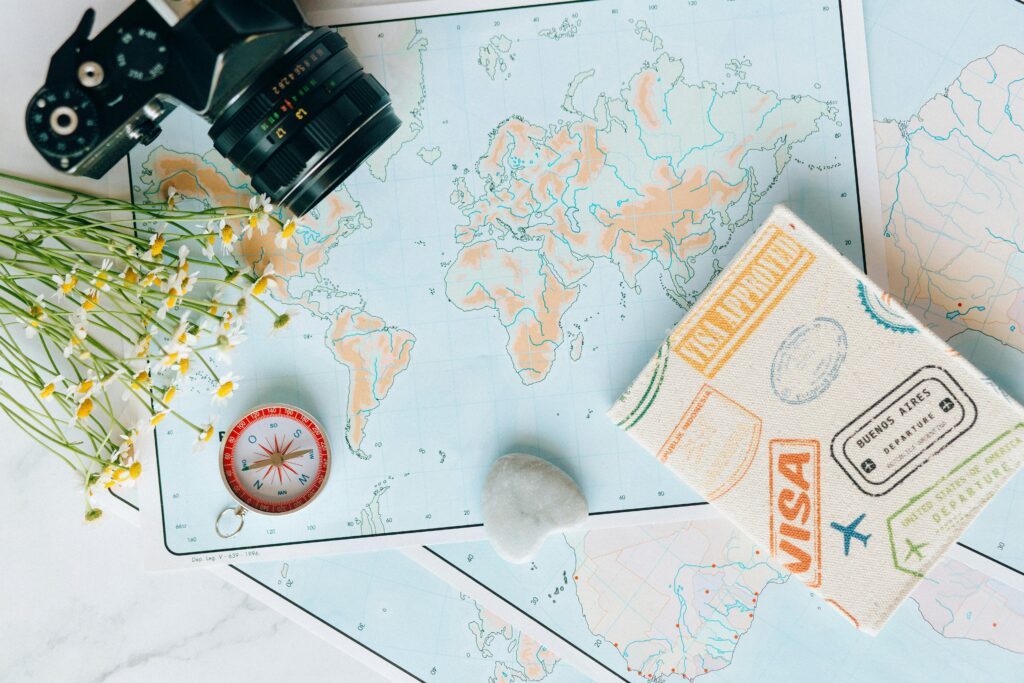pexels-photo-7235804-7235804 Flat lay of travel essentials: maps, camera, compass, and travel journal for planning adventures.